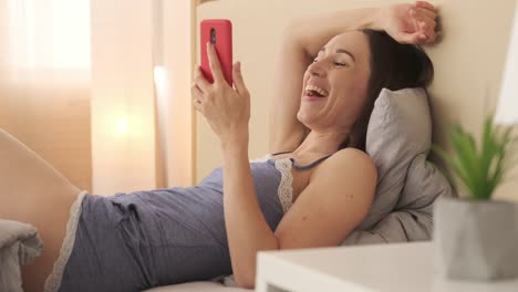 Relaxed-woman-in-nightwear-enjoying-media-content-on-mobile-phone