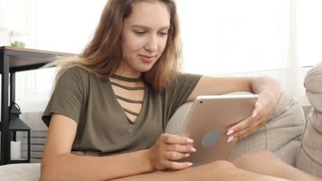 Teenager-Mädchen-mit-digitalen-Tablet-auf-dem-Sofa