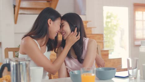 Asian-Lesbian-couple-happy-toothy-smile-looking-to-camera-while-having-breakfast-in-kitchen-in-the-morning.