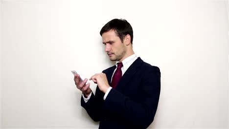 Young-handsome-businessman-leafing-through-news-feed-on-his-smartphone.