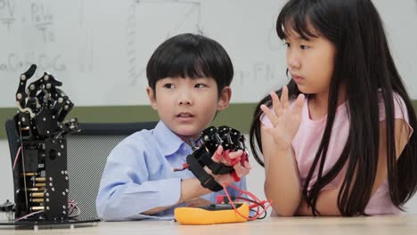 Kinder-spielen-mit-Roboterarm-in-einer-Schule.-Sie-kontrollieren-es-Hand.