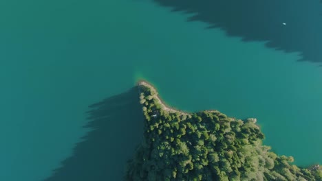 Bergsee-mit-türkisfarbenem-Wasser-und-grünem-Baum