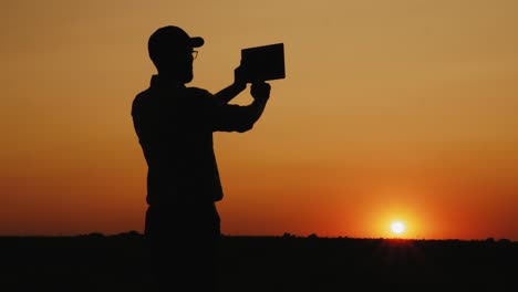 Silhouette-of-a-man-photographing-sunset