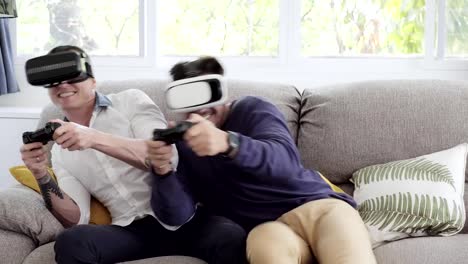 Schwules-Paar-entspannen-dan-auf-der-Couch-spielen-Virtual-Reality-Spiele.-Spannende-Stimmung.-Interessante-Stimmung.-Spaß-Aktion.