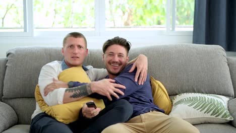 Gay-couple-relaxing-on-couch-watching-tv.-Teasing-each-other.