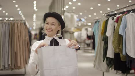 Young-Woman-with-Purchase-Posing-in-Clothing-Store