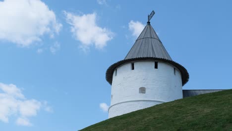 View-of-the-Kazan-Kremlin's-tower-on-a-green-hill-against-blue-cloudy-sky-in-summer-day.-Stock-footage.-Kazan-city,-Tatarstan-republic