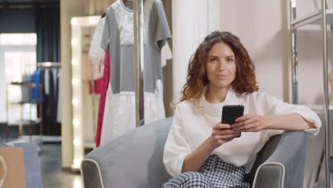 Mujer-descansando-en-el-sillón-en-la-tienda-de-ropa