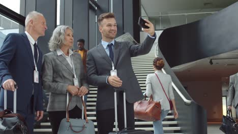 Drei-Geschäftspartner-machen-Selfie-am-Flughafen