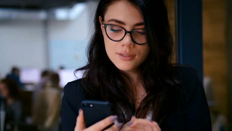 Nahaufnahme-Portrait-der-schönen-jungen-Frau-mit-Smartphone-im-Büro.-Business-Lady-in-formalen-tragen-Kleid-Typing-Nachrichten-auf-ihrem-Handy.