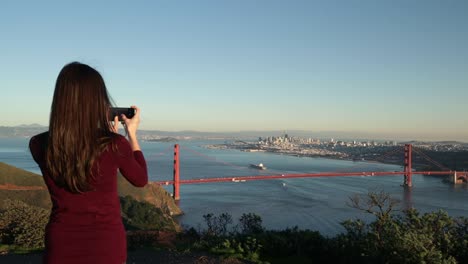 Woman-photographing-the-Golden-Gate-Bridge,-San-Francisco