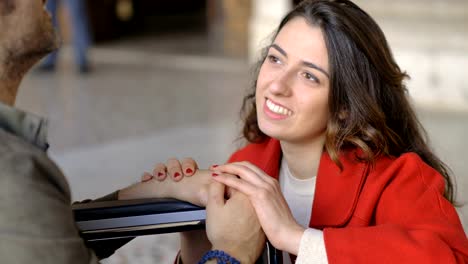 Smiling-attractive-woman-talking-with-her-boyfriend-on-wheelchair.Handicap,love