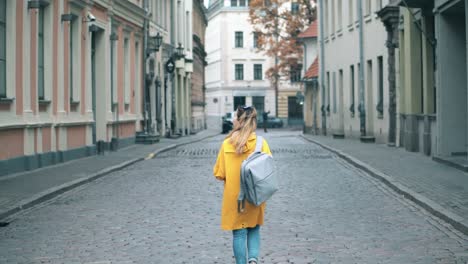 Female-tourist-is-walking-along-the-paved-street-road