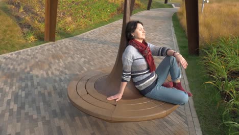 Caucasian-woman-sitting-on-a-park-bench-closed-her-eyes