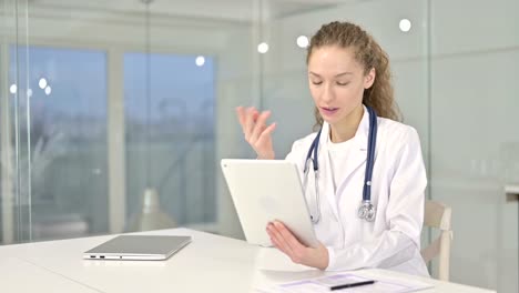 Joven-doctora-haciendo-video-chat-en-la-tableta-en-la-oficina