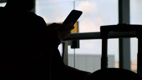 man-with-smartphone-against-window