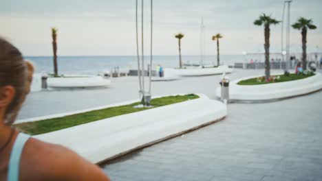 Mujer-activa-con-prótesis-mirando-smartwatch-durante-el-entrenamiento-de-carrera-al-aire-libre,-de-cerca