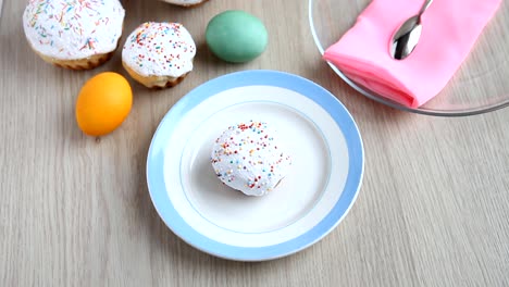 Hands-put-on-the-table-a-plate-with-a-Easter-cake-with-white-icing.