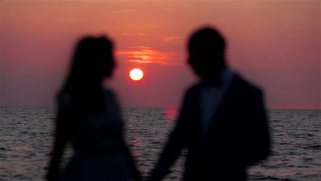 Paar-Hand-in-Hand-bei-Sonnenuntergang-Meer-Hintergrund-Love-Silhouette-hautnah.-Nicht-erkennbare-Unschärfe-Flitterwochen-Mann-und-Frau-stehen-posiert-in-Runde-Sonne-Rosa-Himmel-Ozean-Wellen-Hintergrundbeleuchtung-romantische-Umgebung-festlegen