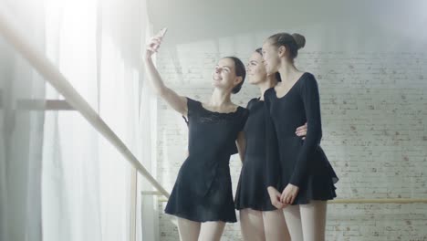 Tres-jóvenes-y-hermosas-Ballerinas-tomando-Selfie-en-un-estudio-luminoso-y-moderno.-Fuera-del-sol-está-brillando.-En-slow-motion.