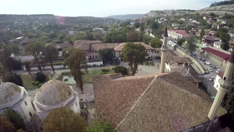 Aerial-view-on-the-old-city-with-church-before-sunset,-sunrise.-Fog,-Cloudy-sky.-Bahchisarai,-Crimea,-Russia.