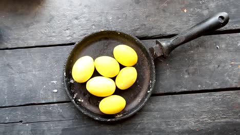 Amarillo-huevos-de-Pascua-en-la-vieja-mesa-rústica