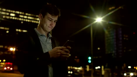 Handsome-guy-is-texting-while-standing-on-a-street