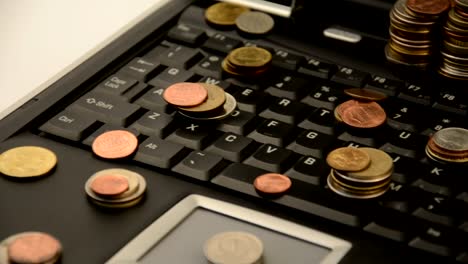 Coins-on-a-laptop-isolated-on-white-background