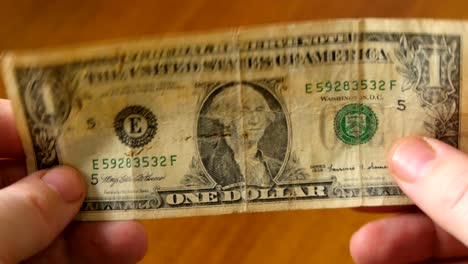 One-american-dollar-banknote-in-male-hands