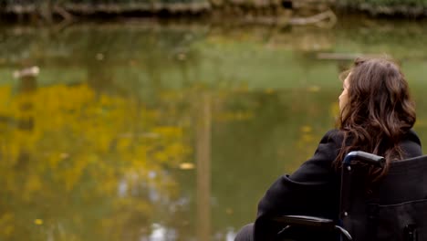 sad-and-depressed-woman-on-wheelchair-contemplates-the-lake