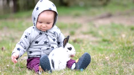 Cute-little-baby-boy,-child-playing-little-bunny-in-park,-outdoors