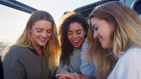 Junge-Erwachsene-Frauen-mit-Smartphone-mit-dem-Auto-unterwegs