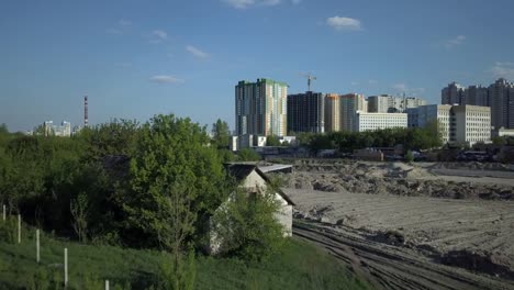 Vista-aérea.-Viejos-edificios-abandonados-se-encuentran-cerca-del-sitio-de-construcción-y-un-nuevo-barrio-con-edificios-de-Apartamento-High-Rise.-Afueras-de-una-megaciudad.-Kiev,-Ucrania