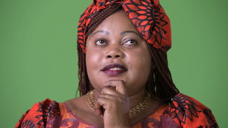 Overweight-beautiful-African-woman-wearing-traditional-clothing-against-green-background