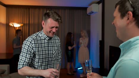 Attractive-guys-drinking-champagne-and-talking-at-birthday-party