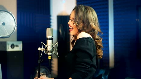 Girl-singing-to-the-microphone-in-a-studio.