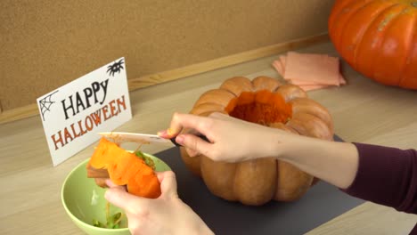 Women's-hands-clean-the-pumpkin-cover-from-the-seeds-for-halloween