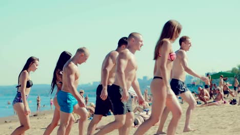 Group-of-friends-are-walking-along-the-beach.-Side-view