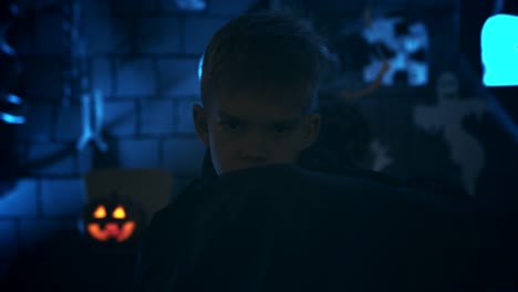 Young-boy-in-a-vampire-costume-for-Halloween-showing-his-scary-face-and-teeth-to-camera