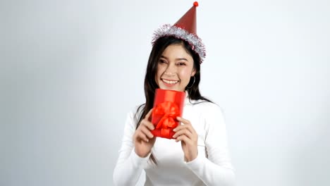 mujer-joven-feliz-con-sombrero-y-sosteniendo-una-caja-de-regalo-de-Navidad-Roja-sobre-un-fondo-blanco