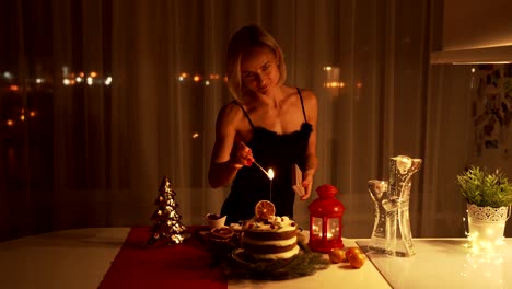 Young-woman-lighting-a-Sparkler-in-the-cake-at-night-at-Christmas-time