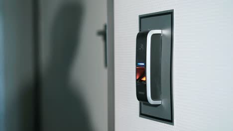The-man-puts-his-finger-on-a-fingerprint-scanner-which-is-designed-to-enter-the-door.-Modern-security-technology-in-everyday-lives-of-employees.-Work-of-protection-against-burglary-close-up