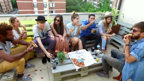 Vista-de-ángulo-alto-de-amigos-comiendo-pizza-en-la-terraza-de-la-azotea