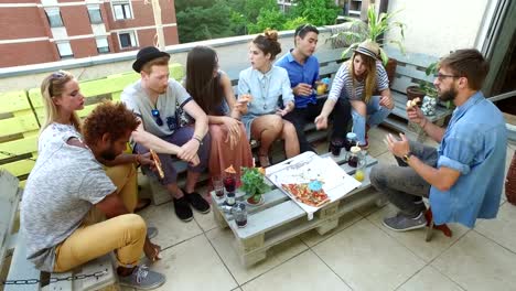 Vista-de-ángulo-alto-de-amigos-comiendo-pizza-en-la-terraza-de-la-azotea