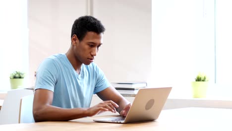 Junge-schwarze-Mann-arbeitet-auf-Laptop