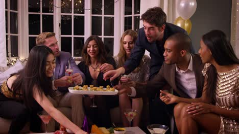 Friends-Eating-Snacks-As-They-Celebrate-At-Party-Together