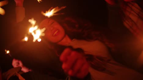 Young-friends-celebrating-with-sparklers-at-night