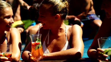 Lächelnd-Womens-Cocktails-trinken-und-Spaß-im-pool