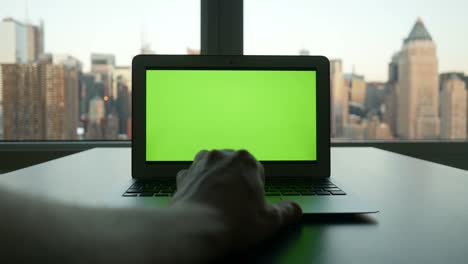 Computer-mit-Greenscreen-in-moderne-Bürogebäude-mit-Stadtbild-Hintergrund.