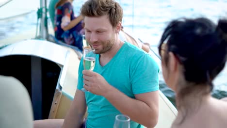 Junge-Freunde-genießen-Zeit-auf-Segelboot-mit-Party-mit-Champagner